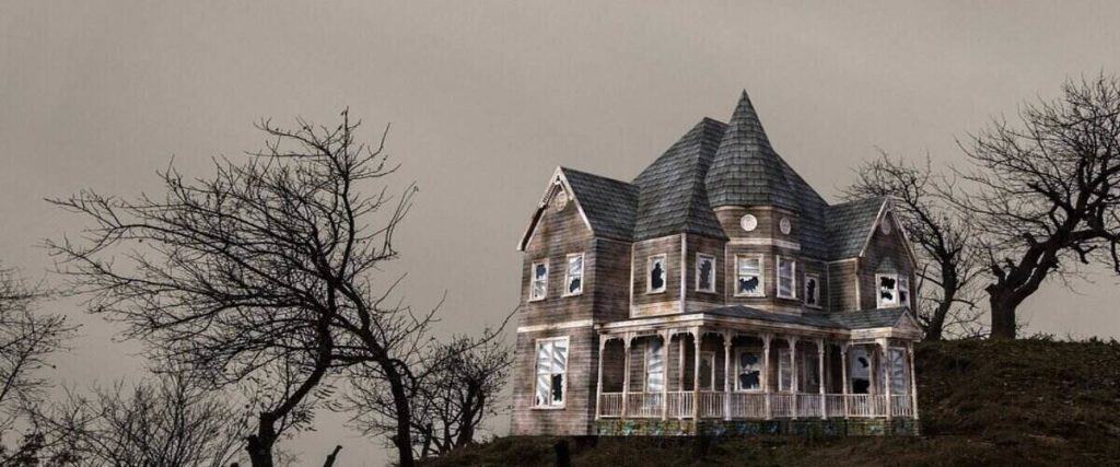 dark image with a haunted house with broken windows and trees with no leaves surrounding it