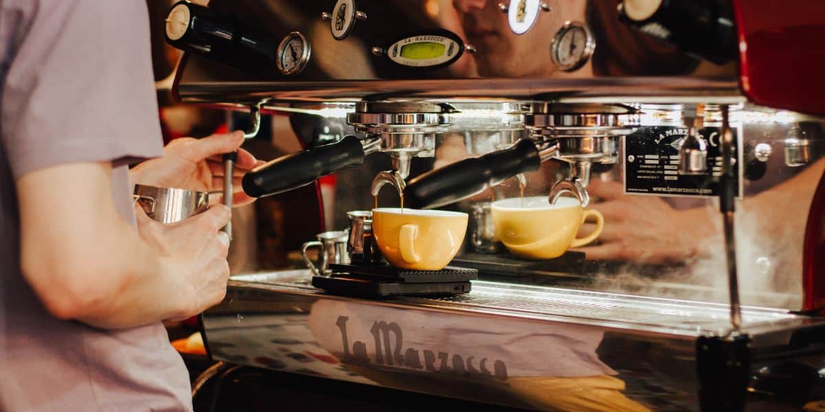 A man making coffee with an espresso machine.