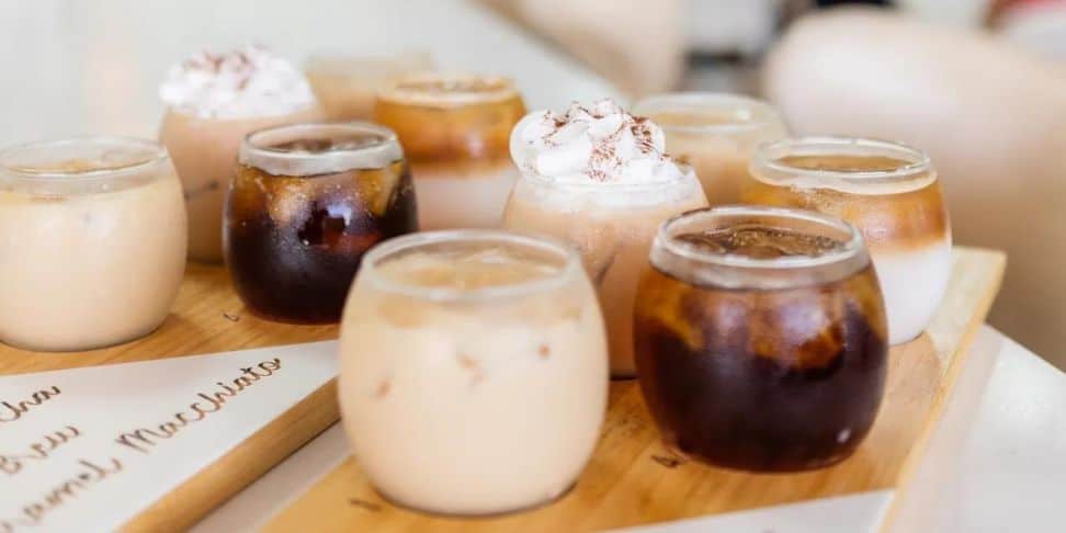 A selection of iced coffee drinks on a wooden tray.
