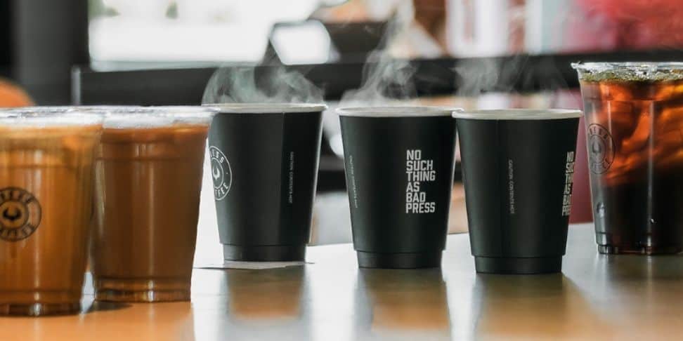 A group of coffee cups on a table with steam coming out of them.
